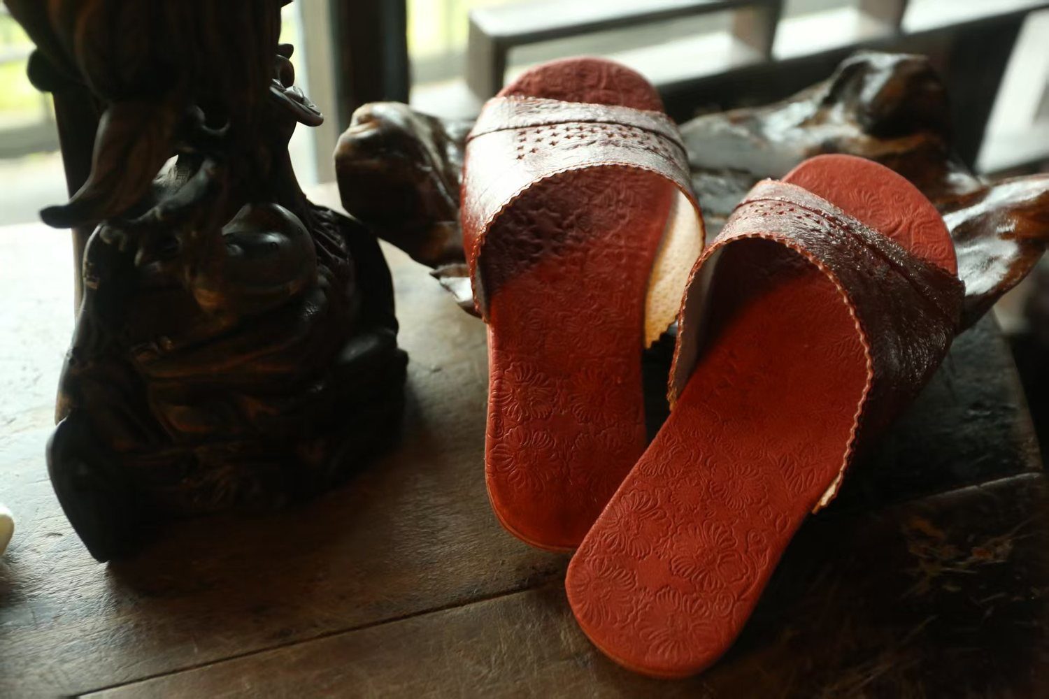 Red leather slippers on table